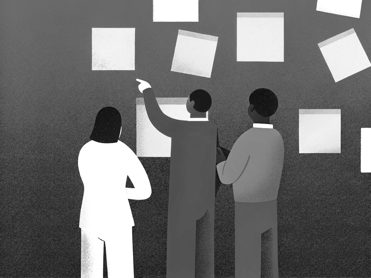 Three people collaborating on a product roadmap with sticky notes.